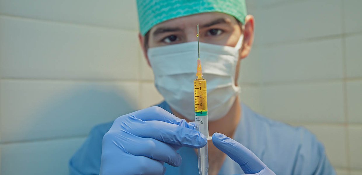 Photo of medical personnel holding a vaccine syringe