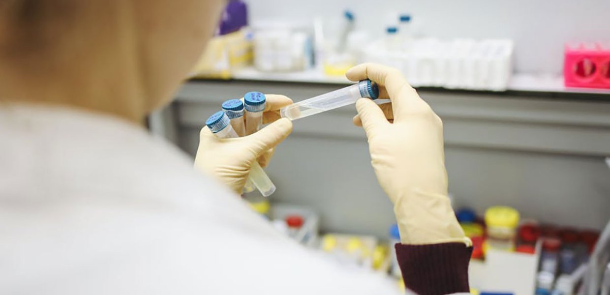 Photo of a person holding four vaccine vials in their hands