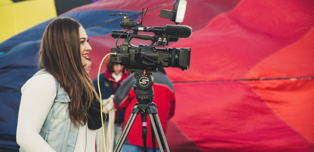 Photo of a person operating a news camera