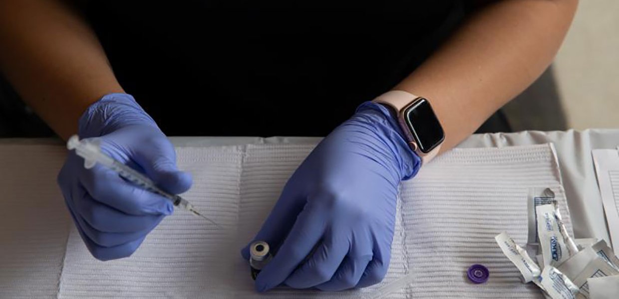 Photo of a person preparing a vaccine for administration