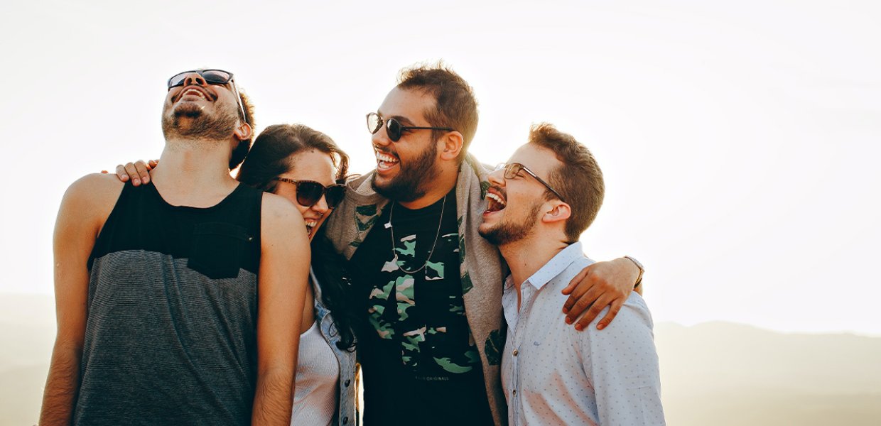 A photo of four people laughing. 