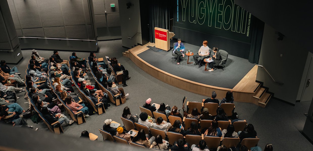 Overhead view of a conversation between Hye Jin Lee and K-pop star Yugyeom.
