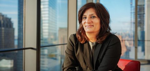 Devika Bulchandani sitting in her office in front of a window. 