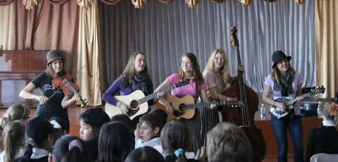 The bluegrass group Della Mae plays at an orphanage in Kyrgyzstan on its State Department-sponsored American Music Abroad tour in 2012. Photo: Paul Rockower
