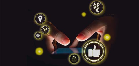 Out of the black darkness, a phone screen lights up with two thumbs touching the screen. Social media-related icons hover in yellow circles around it.