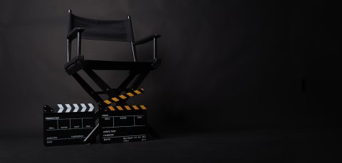 A director's chair over a blank black screen. 