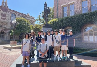 Photo of a group of students by a statue