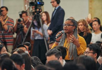 Photo of a person speaking in a group of people