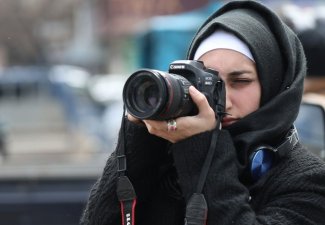 Woman taking photograph.