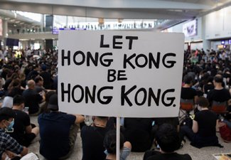 Photo of a protestor holding a sign that reads "Let Hong Kong be Hong Kong"