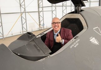 Man giving thumbs up while sitting in a seat.