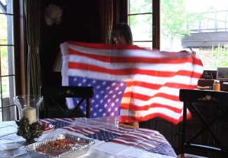 Screenshot from a video of a person holding an American flag upside down