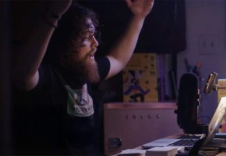 A man behind a ring light at a desk