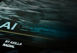 The word AI on a computer screen, with hues of green and blue