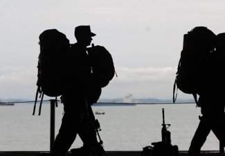 Silhouette of army men walking single file