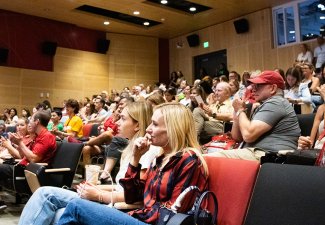 An audience watching intently in an ASC auditorium