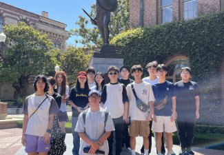 Photo of a group of students by a statue