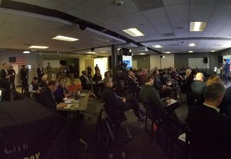 A group of people in a room watching a presentation