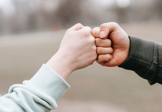 Photo of two people fist bumping
