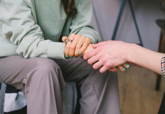 Crop psychologist supporting patient during counseling indoors