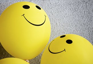 Photo of some yellow balloon with smiling faces on them