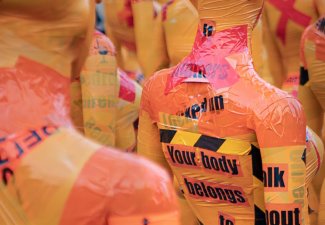 Image of mannequins wrapped in caution tape and other material. One reads "Your body belongs to you"