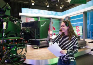 Photo of a USC Annenberg student in the media center studio