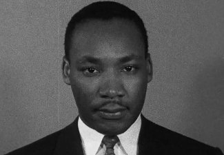 Black and white photo of Martin Luther King Jr. looking directly at the camera.