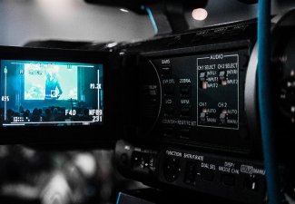 Photo of a black camera recording a film event