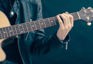 Photo of a person palying a guitar