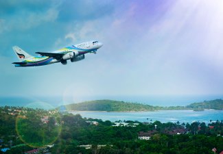 Photo of airplane flying over a tropical landscape