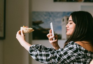 Photo of a person taking a picture of their food
