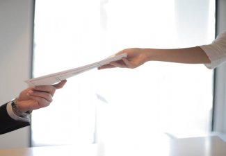 Photo of people passing paper between them