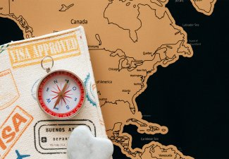 Visa and compass laid atop a map of North America