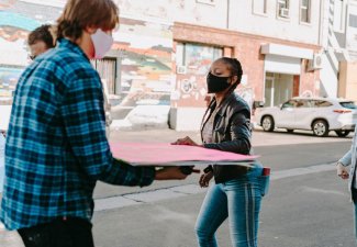 Photo of people holding boards and walking