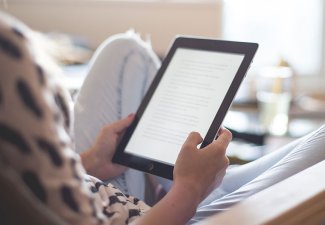 Photo of a person reading from a tablet
