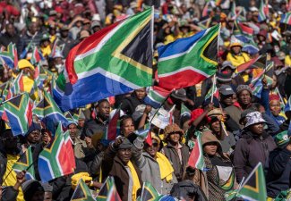 Crowd of people waving the flag of South Africa