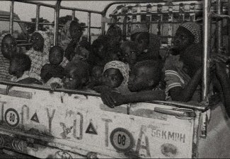 Women and children in a car in Nigeria. Black and white.