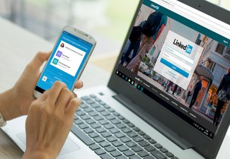 Photo of a person using LinkedIn on a computer and on a mobile phone app