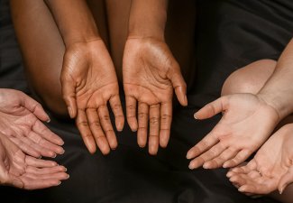 Photo of three sets of hands with palms facing upward