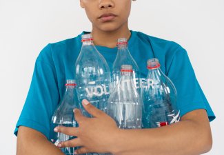 Image of a person holding empty plastic bottles