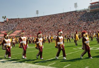 The USC marching band playing during a sporting event in the coliseum.