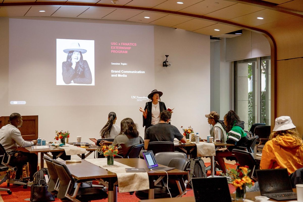 A teacher presenting slides in front of a classroom.