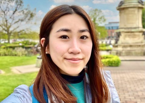 Young asian woman takes selfie in front of outdoor landscape