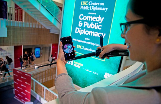 A student takes a photo of an event. 