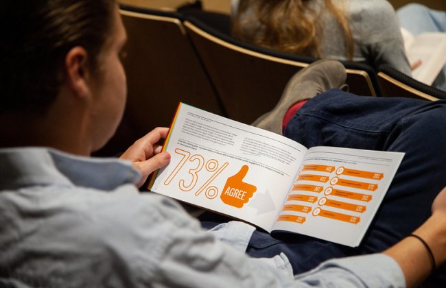 A person reading a report at an assembly.