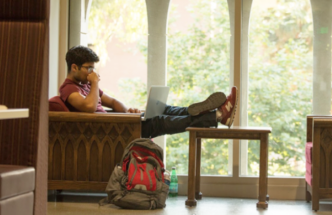 Photo of a person sitting with their legs on a table 