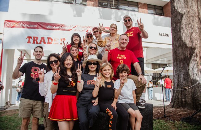USC students, alumni, and family all gathered with a "Fight On!" sign on campus