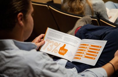 A person reading a report at an assembly.