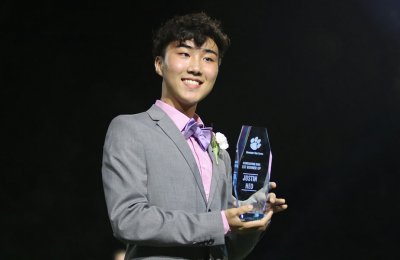 Photo of Justin Heo holding his first runner-up homecoming King trophy at his Dunwoody High School outside of Atlanta, Georgia